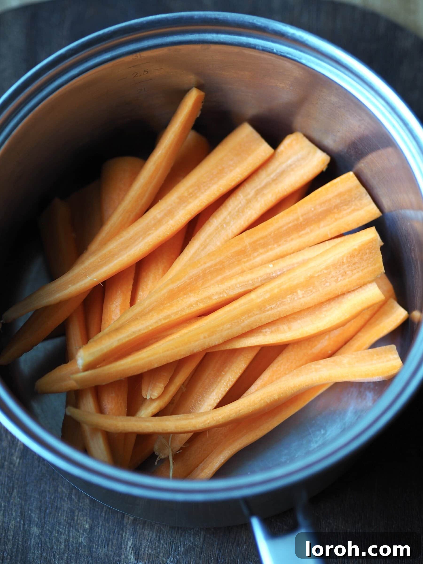 Cut carrot batons in a saucepan.