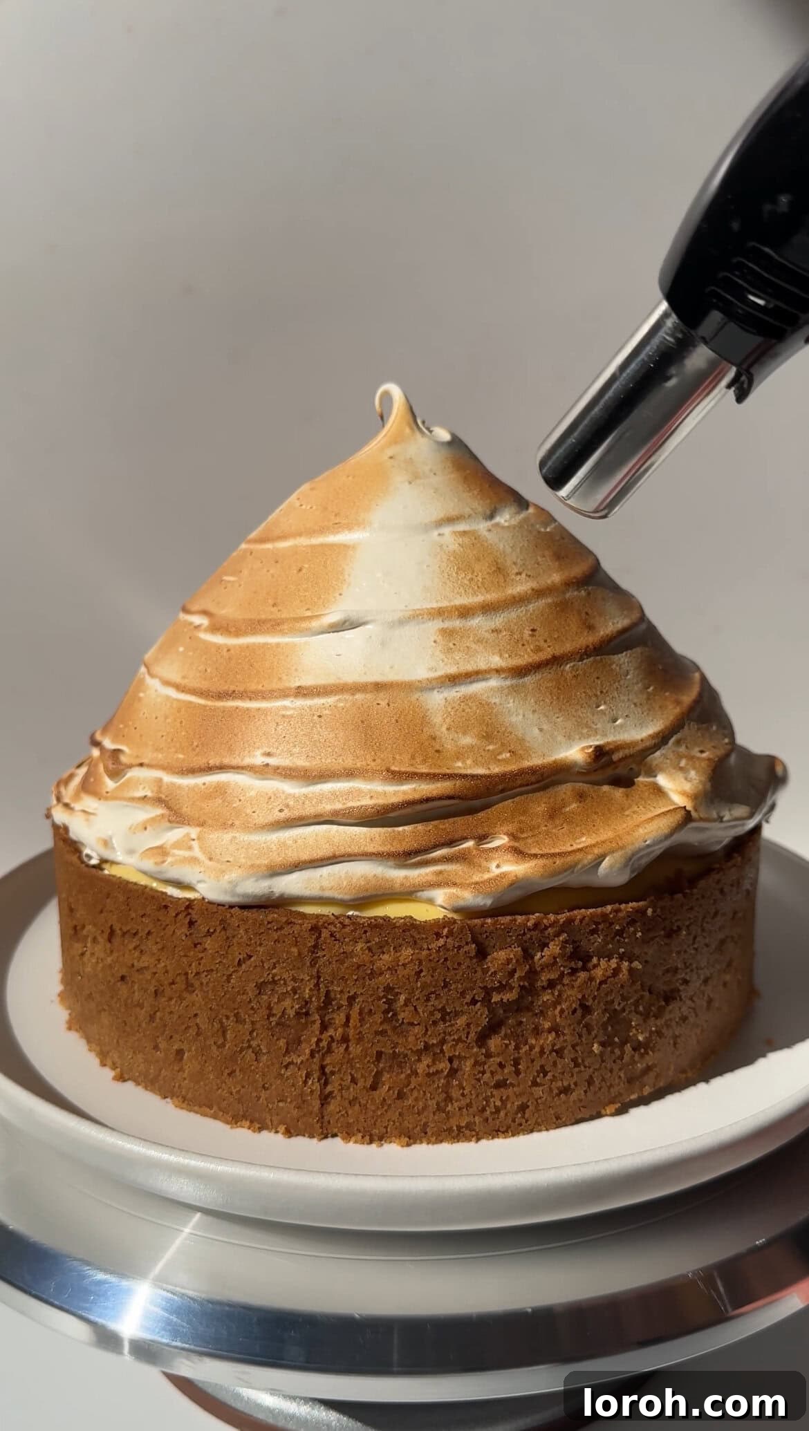 Zesty Lemon Meringue Delight 16 using a blowtorch to toast the meringue topping on the lemon meringue cheesecake
