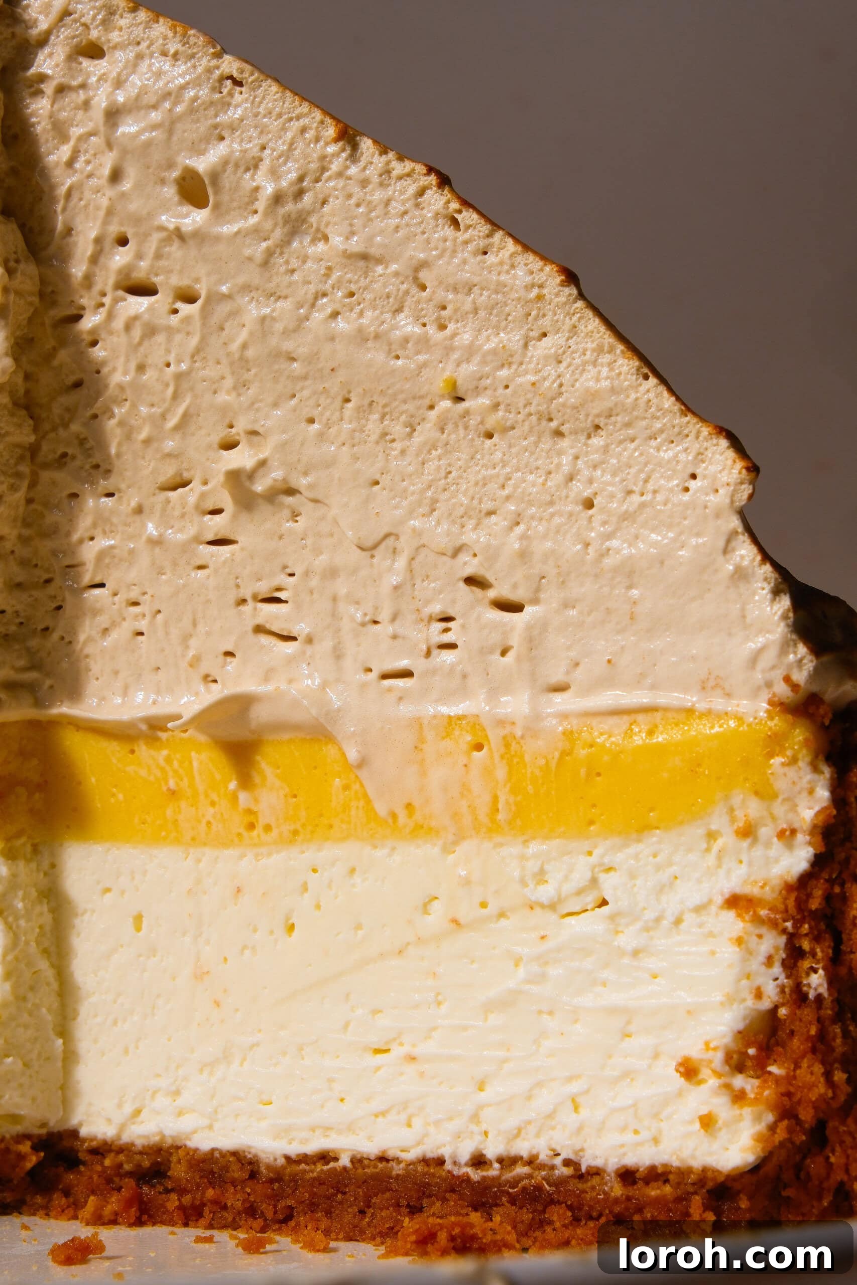 Zesty Lemon Meringue Delight 3 close-up of lemon meringue cheesecake with a golden meringue topping