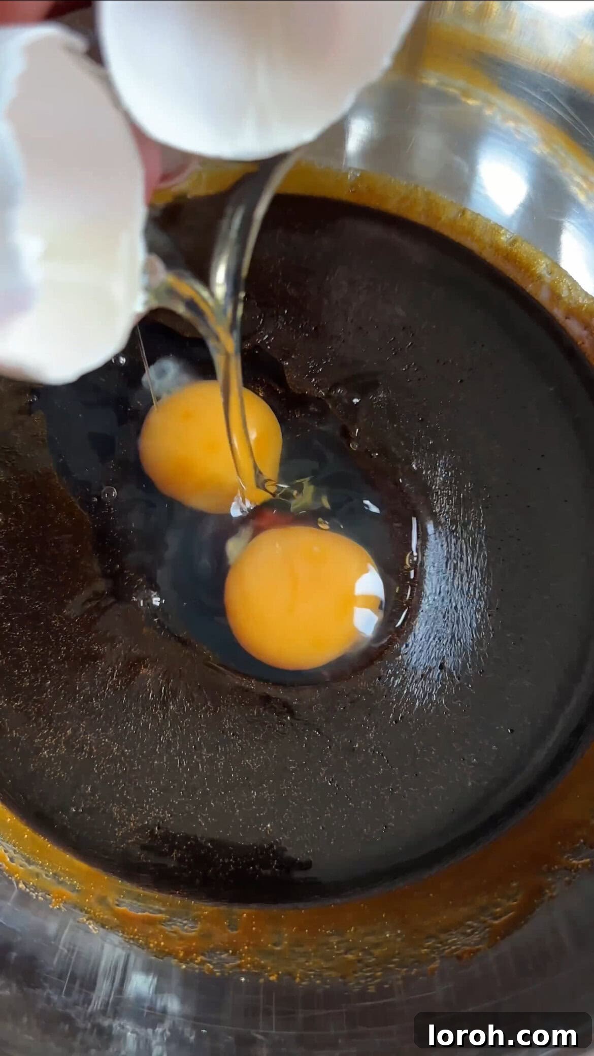 Island-Spiced Jamaican Ginger Cake 6 Beating eggs into the cooled butter and treacle mixture.