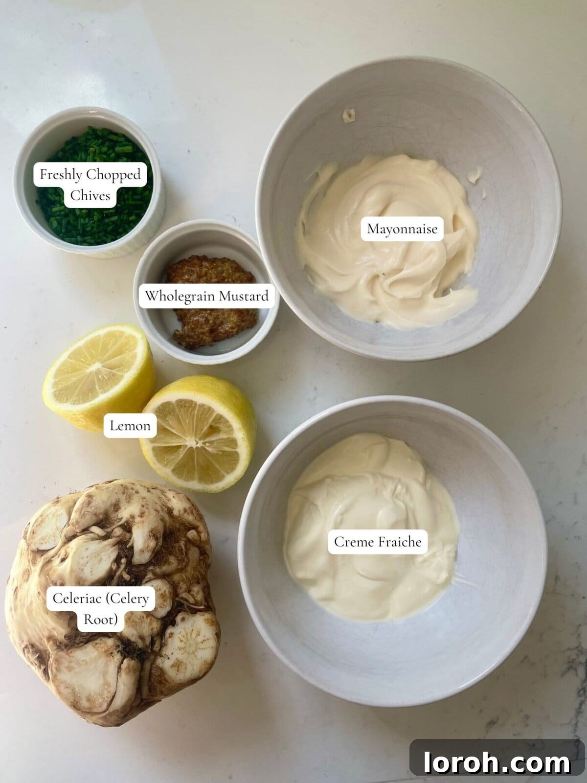 Zesty Celeriac Remoulade 3 Labeled ingredients laid out on a surface, including mayonnaise, crème fraîche, mustard, lemon, chives, and a whole celeriac, ready for making celeri remoulade.
