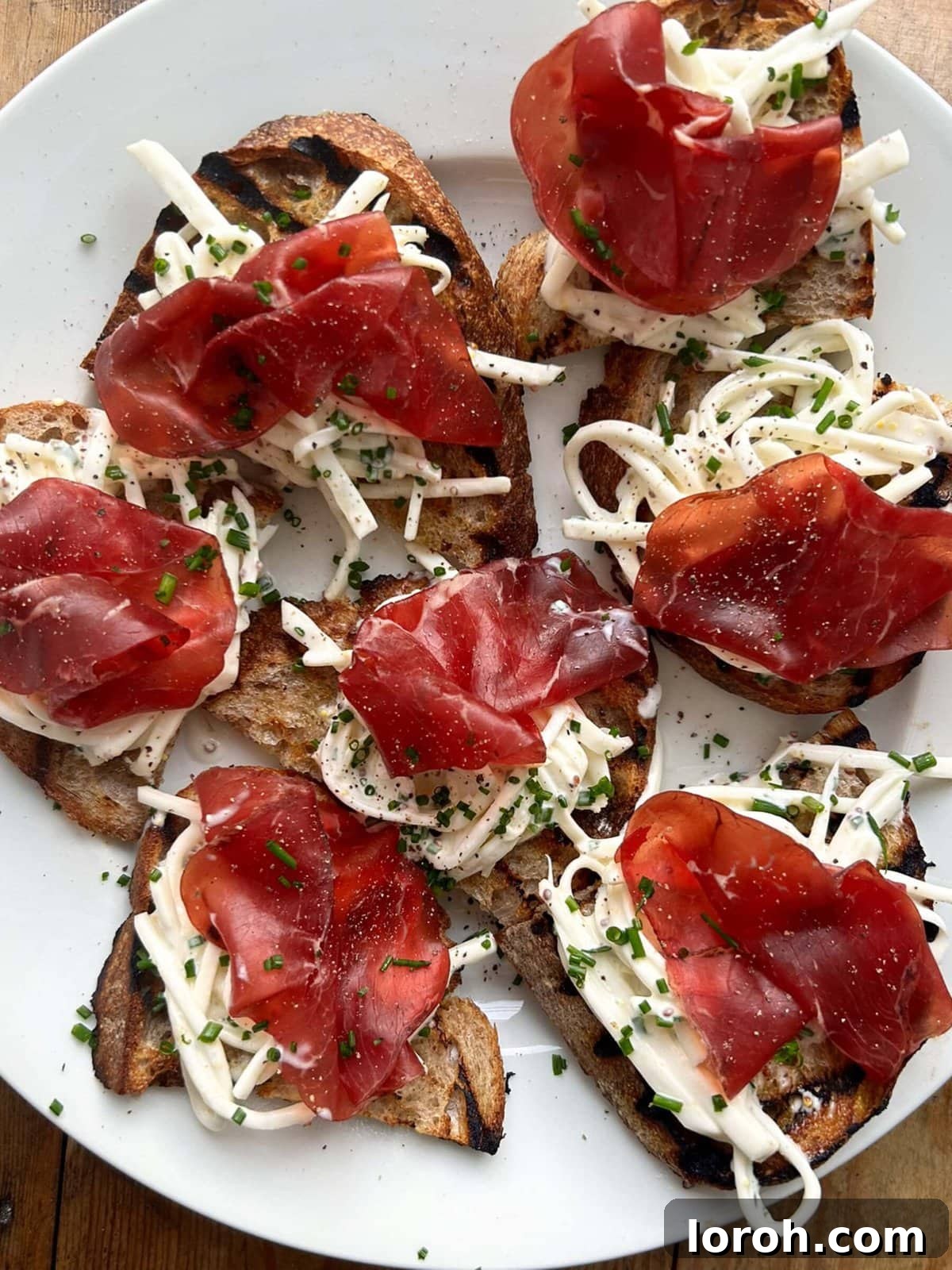 Zesty Celeriac Remoulade 4 Close-up of Celeri Remoulade served on toast, garnished with fresh chives and topped with thin slices of bresaola, illustrating an elegant canapé option.