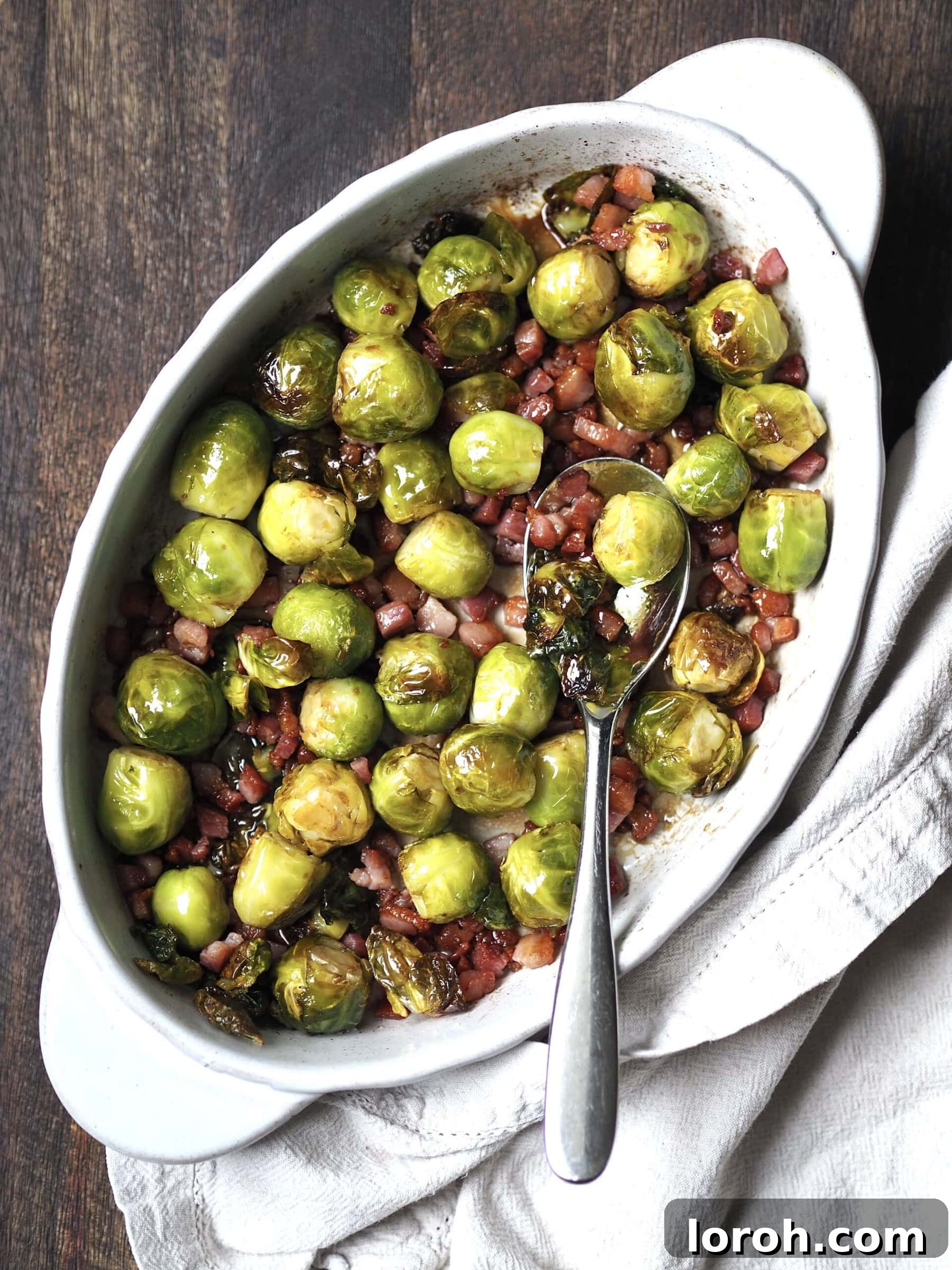 White serving dish of honey bacon balsamic roasted brussels sprouts. 