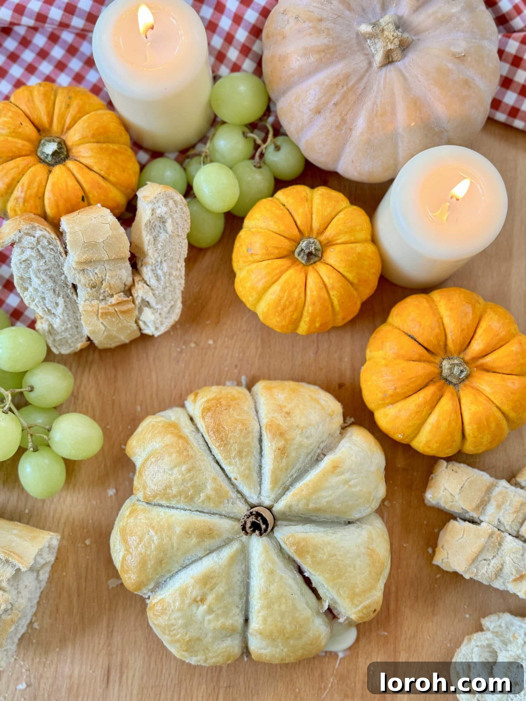 Garlic Cranberry Baked Brie in a Pumpkin Puff Pastry 2 Golden baked Camembert and Cranberry Puff Pastry shaped like a pumpkin, ready for serving on a rustic board.