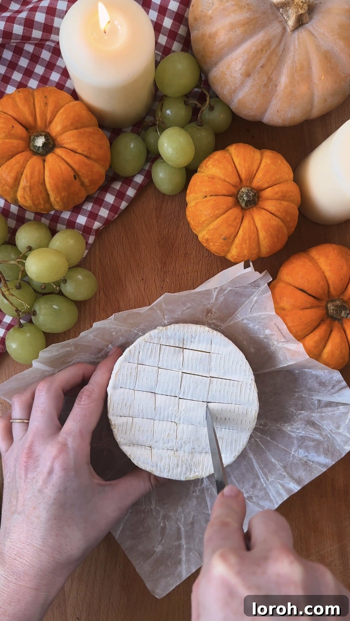 Garlic Cranberry Baked Brie in a Pumpkin Puff Pastry 4 Scoring the top of a wheel of brie cheese with a sharp knife before adding garlic.