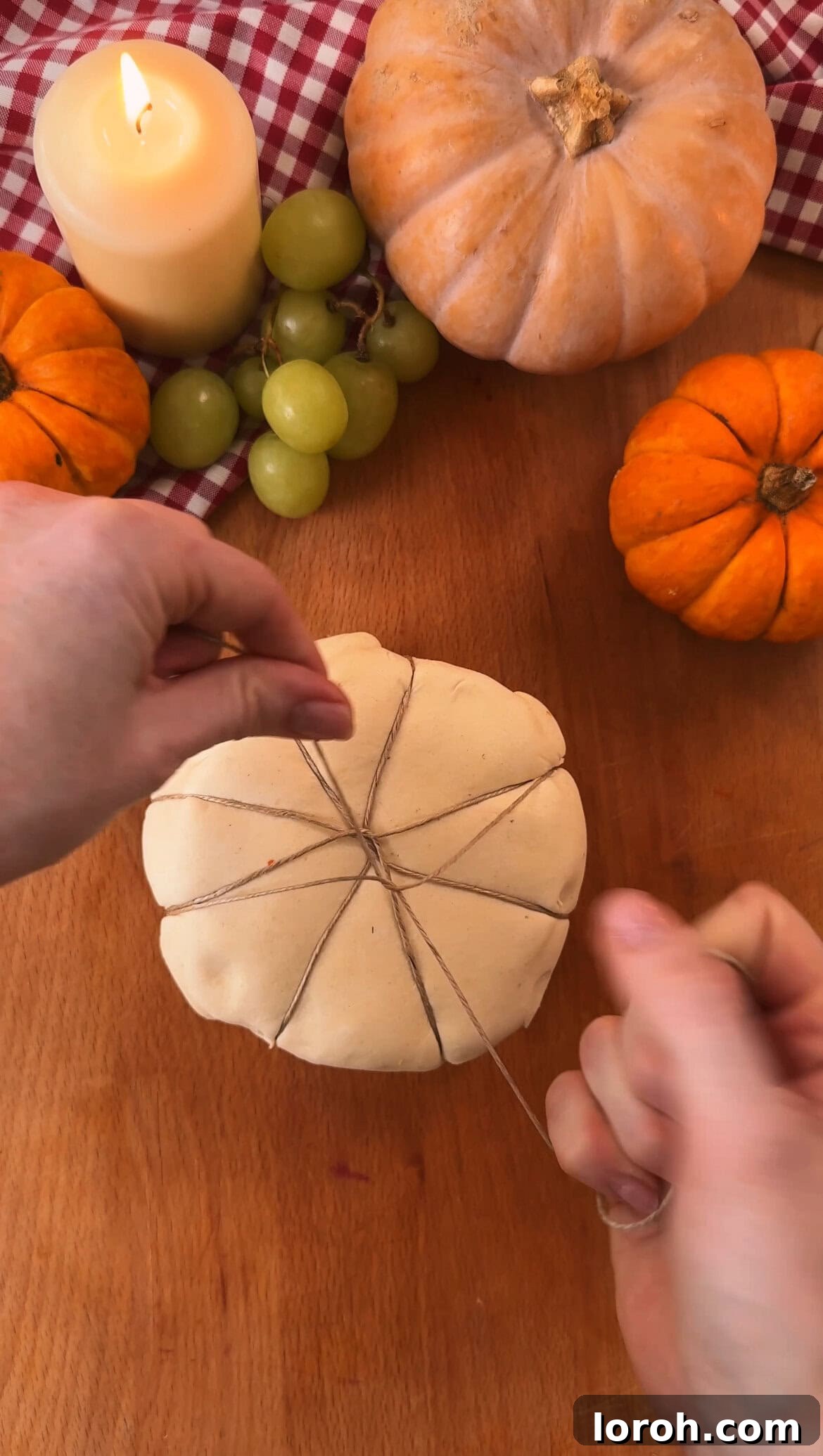 Garlic Cranberry Baked Brie in a Pumpkin Puff Pastry 7 Tying string around the puff pastry parcel to create pumpkin segments.