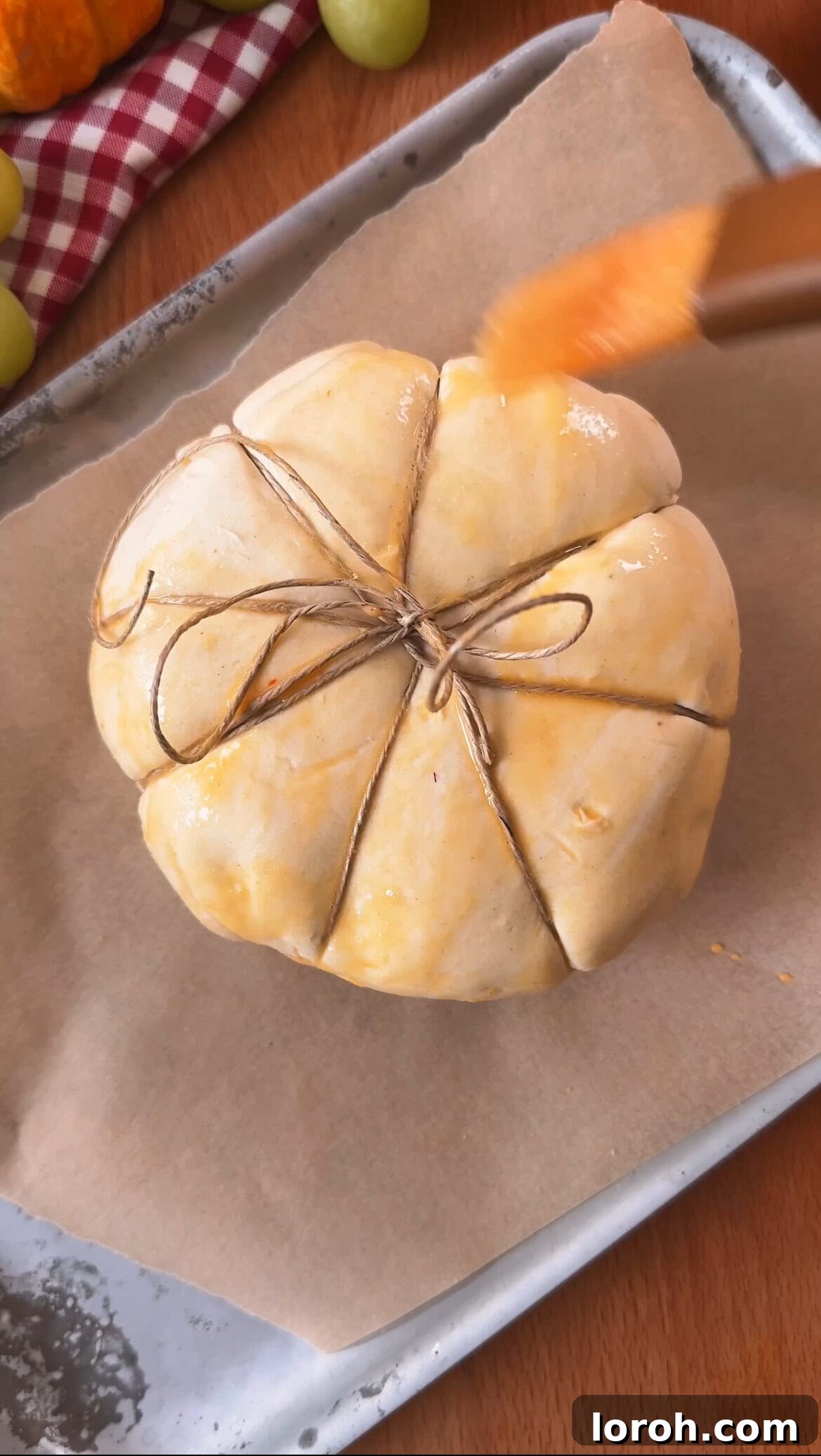 Garlic Cranberry Baked Brie in a Pumpkin Puff Pastry 8 Brushing the pumpkin-shaped pastry with egg wash before chilling.