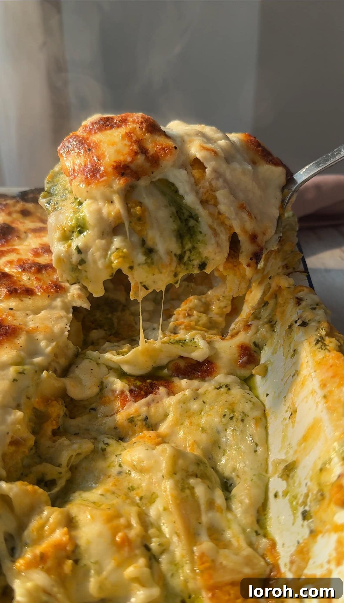 Basil Bliss Lasagna Bake 14 A serving of Pesto Lasagne al Pesto being scooped from a baking dish, highlighting its creamy layers.