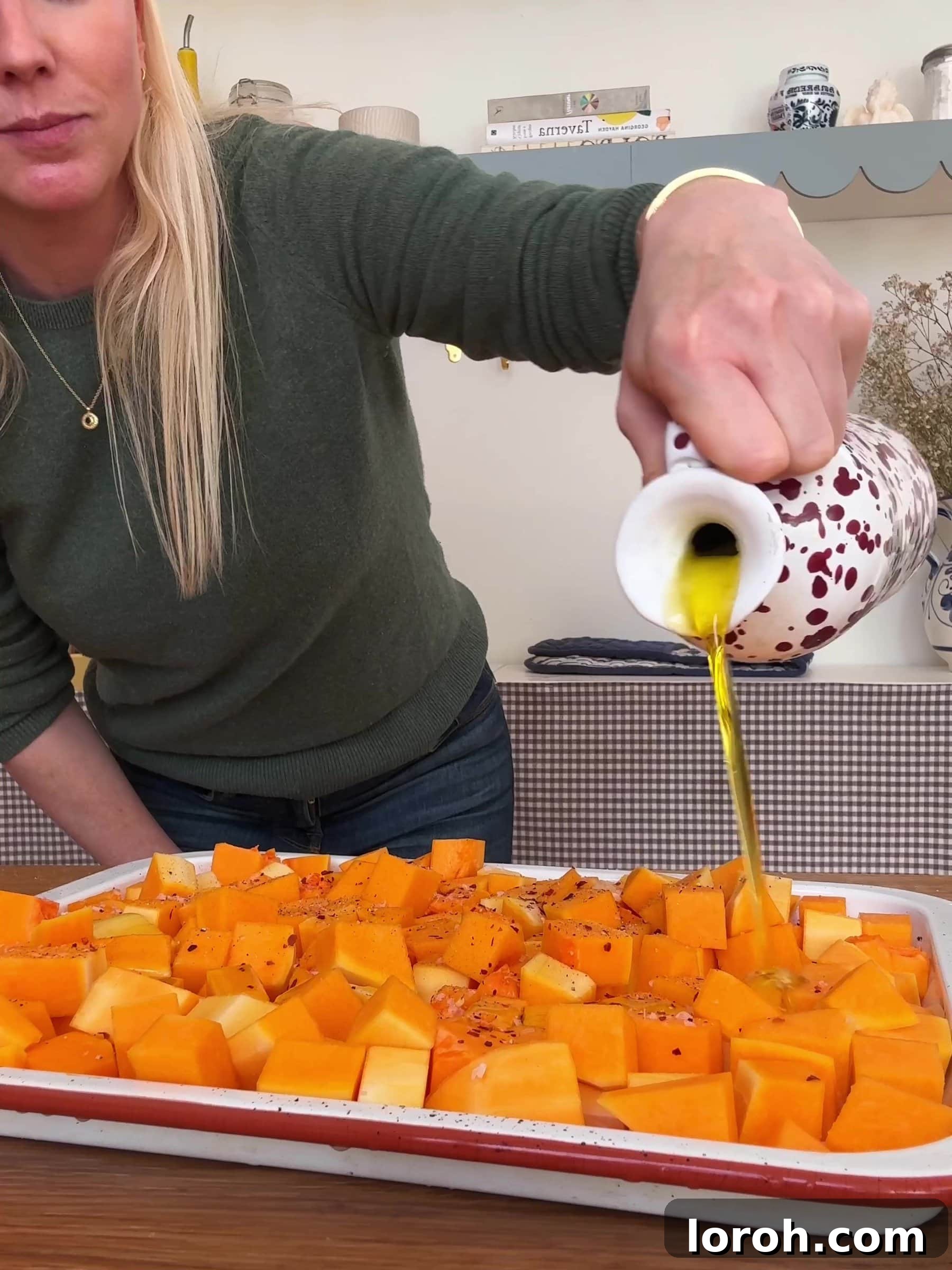 Basil Bliss Lasagna Bake 5 Drizzling olive oil over seasoned butternut squash on a baking tray before roasting.