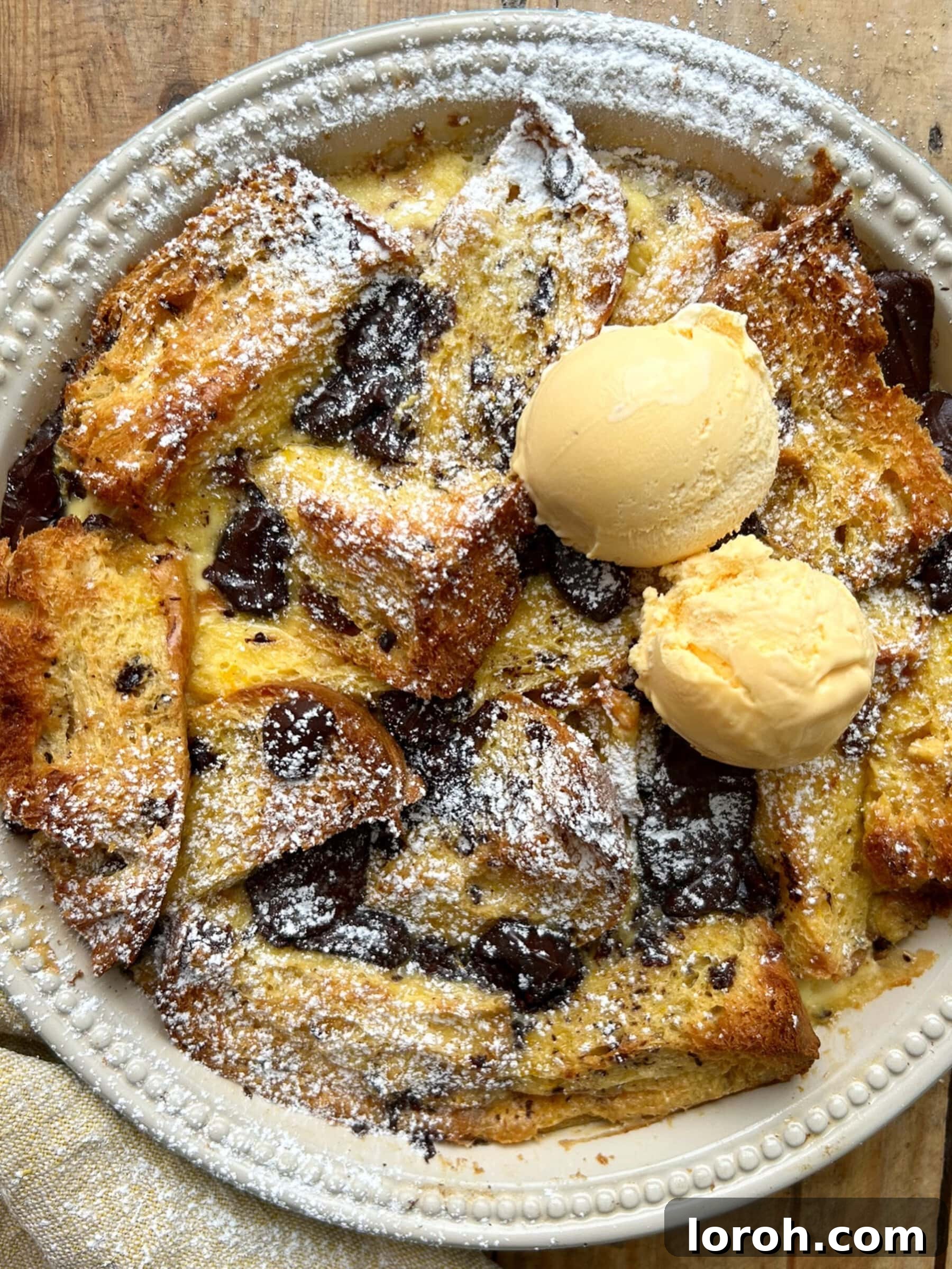 Panettone, Orange and Dark Chocolate Bread and Butter Pudding in a dish topped with ice cream