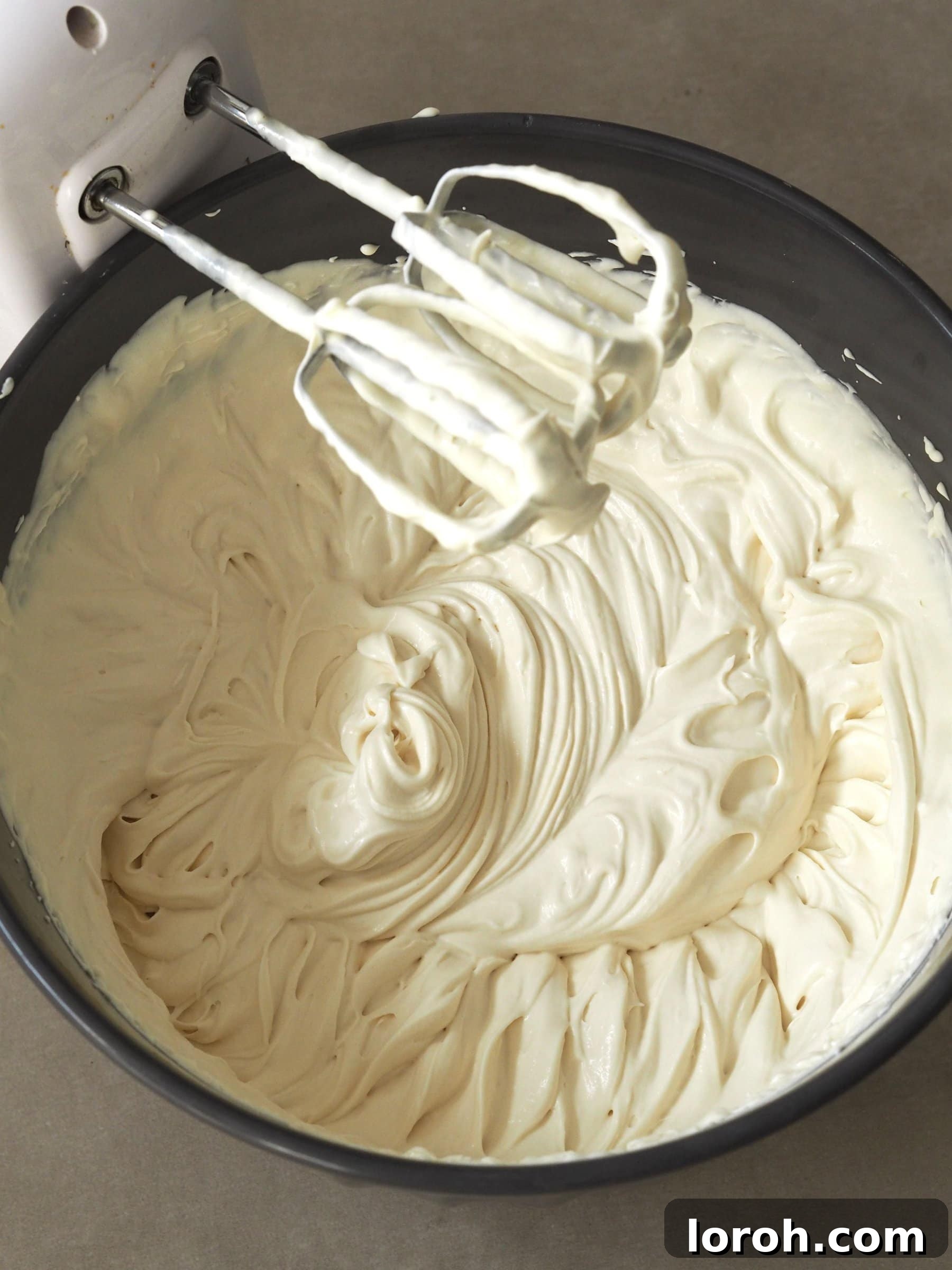 Baileys Velvet Ice Cream 4 Whisking heavy cream in a large mixing bowl to achieve soft peaks.
