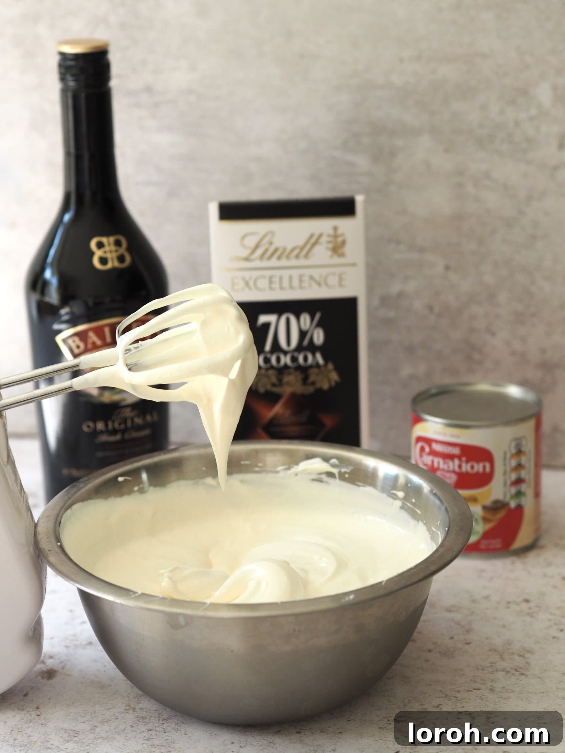 Baileys Velvet Ice Cream 5 A bowl containing whipped cream, condensed milk, and Baileys liqueur, ready to be combined.