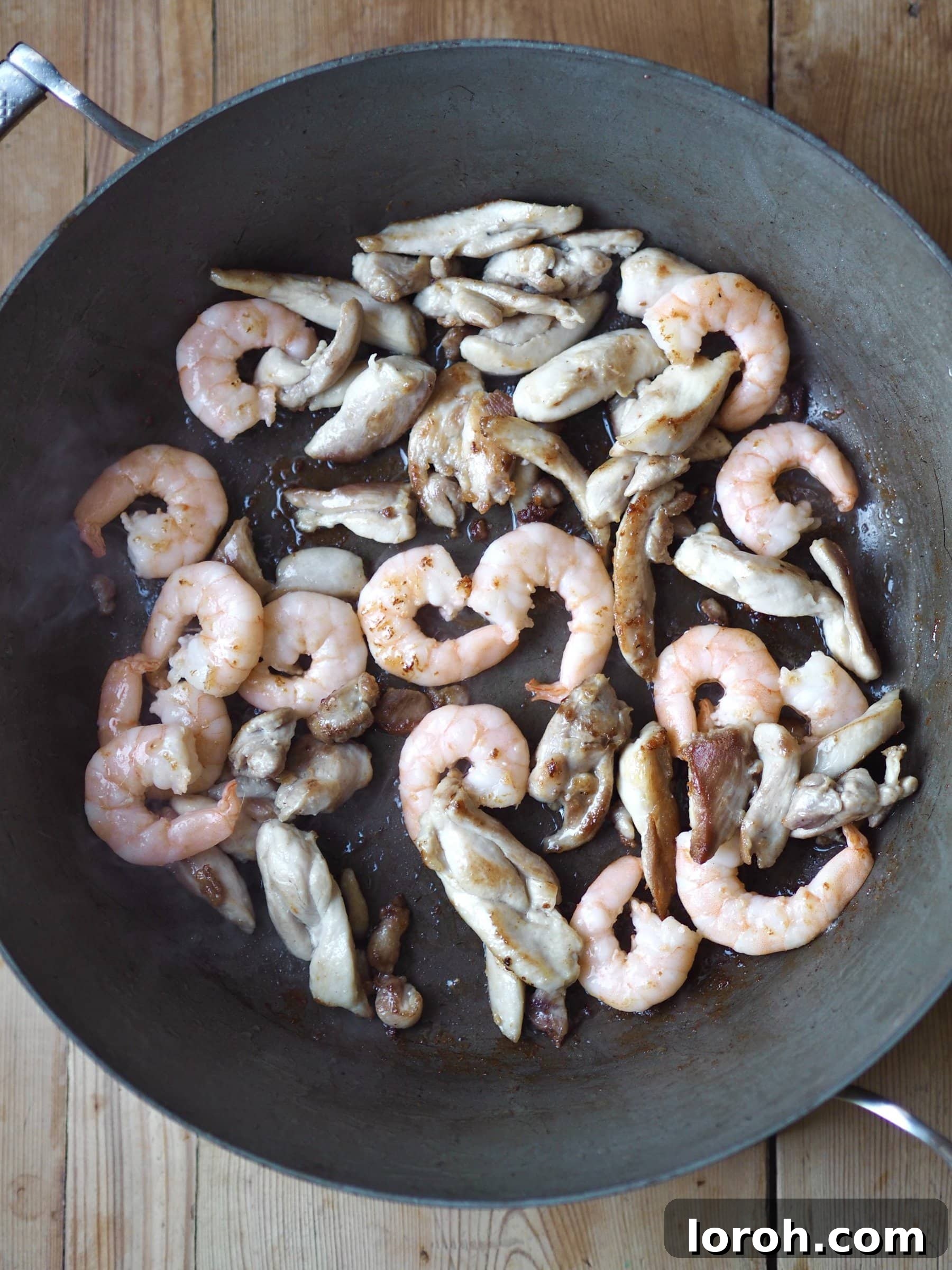 Double Delight Fried Rice 5 Frying prawns and chicken strips in a pan