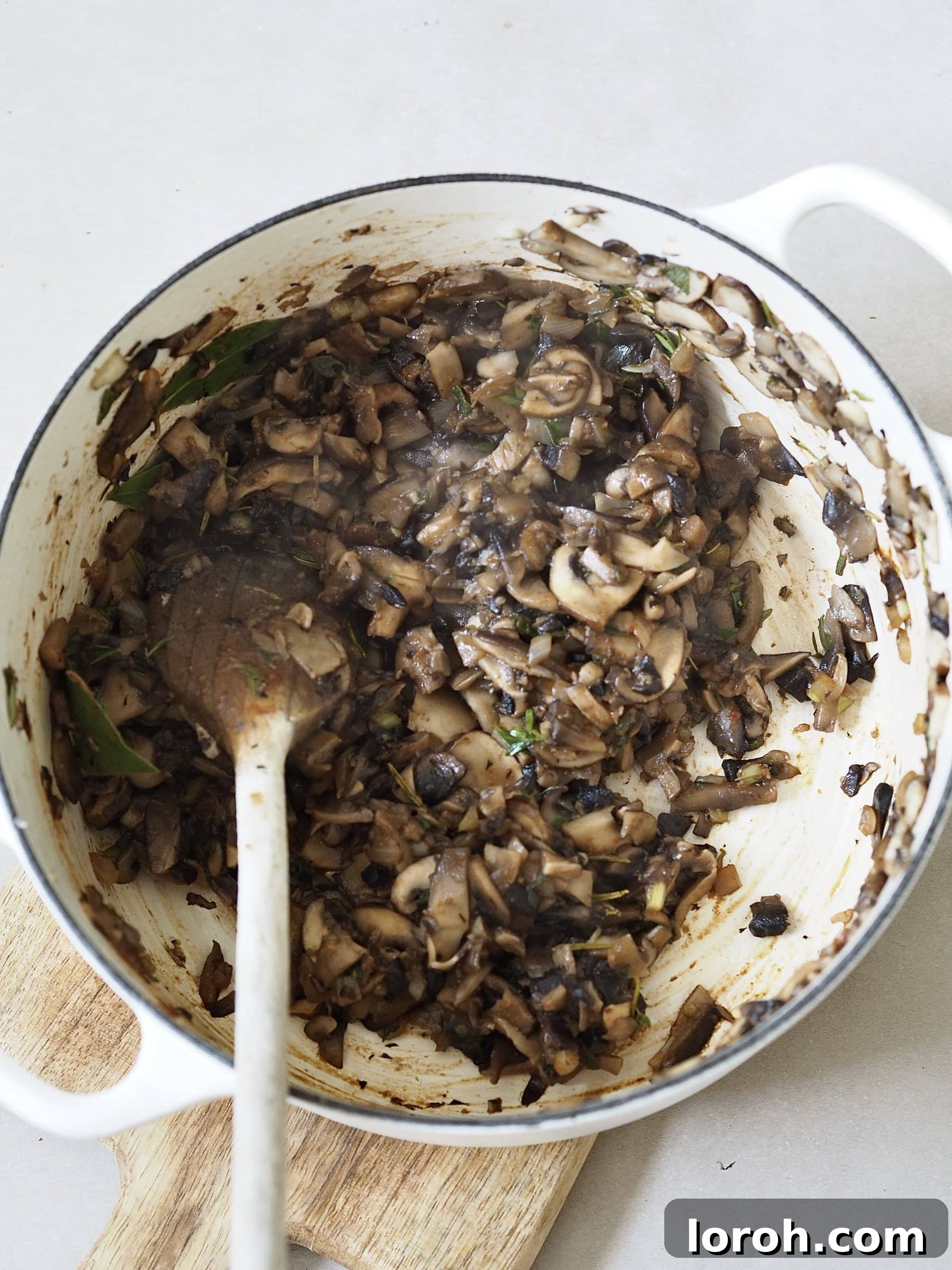 Sautéing finely chopped mushrooms, onions, and celery for the Wellington filling