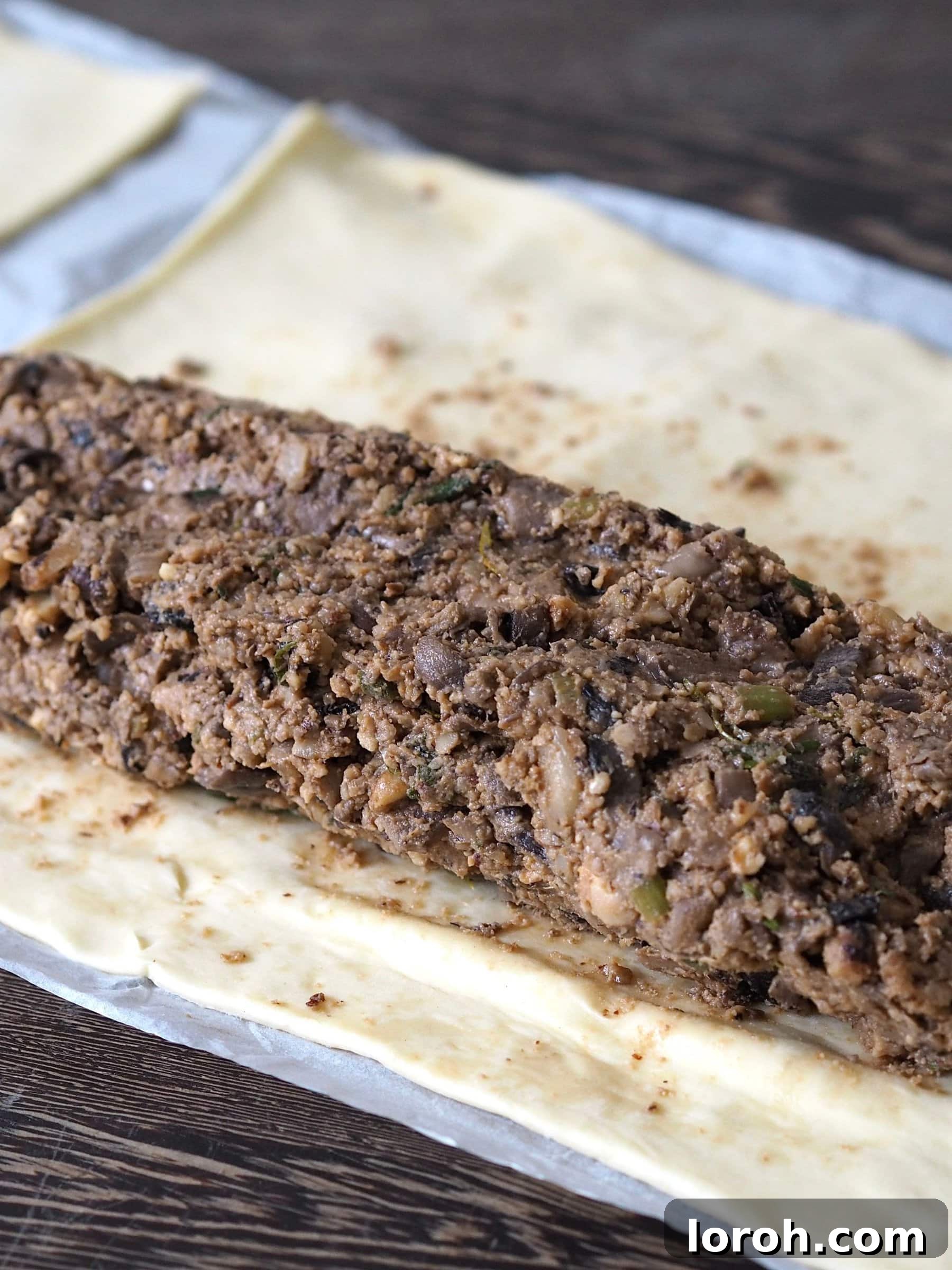 Unrolled puff pastry sheet with the shaped nut roast filling placed in the center