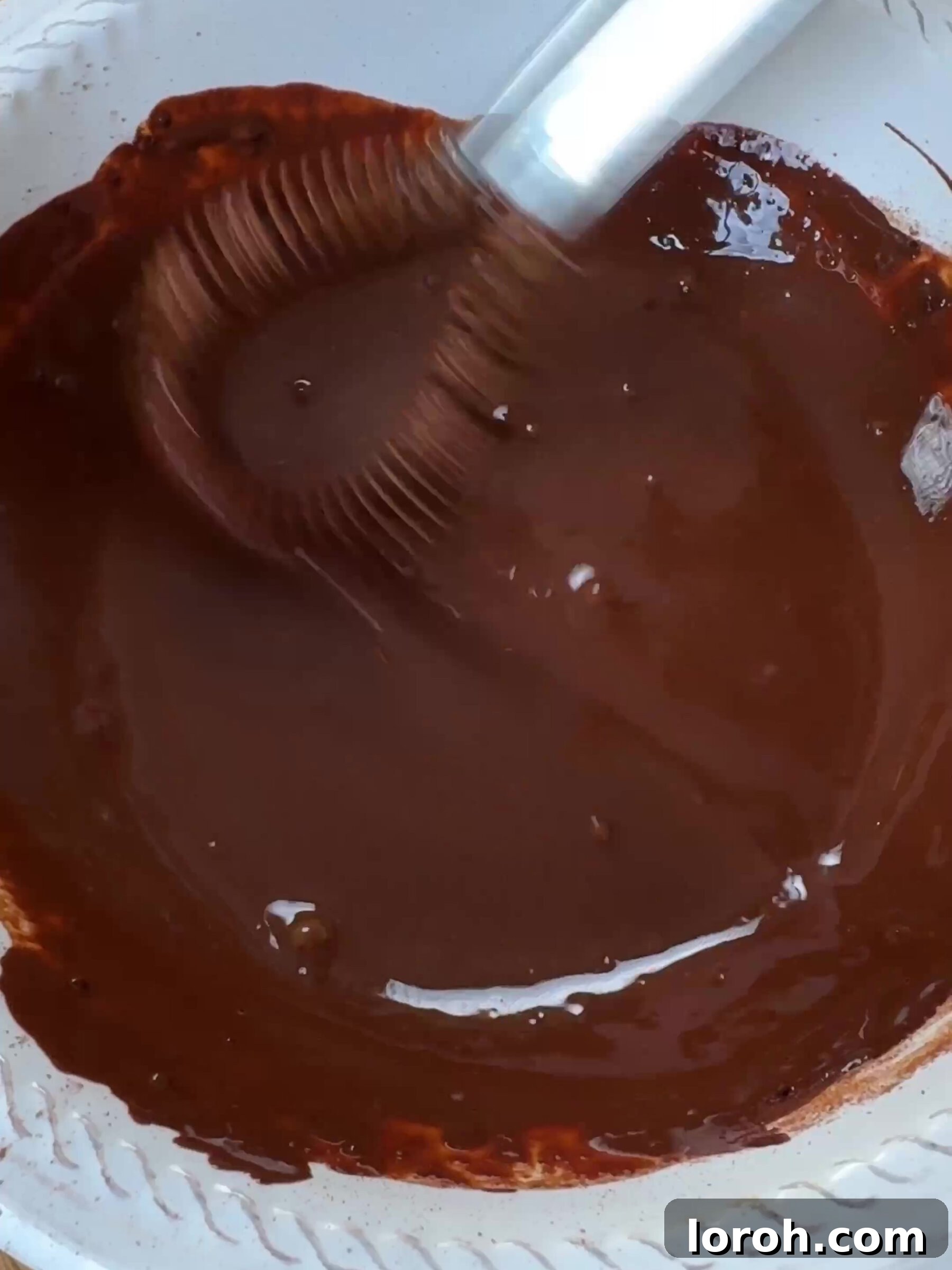 Whisking cocoa powder, boiling water, and instant coffee together in a small bowl.
