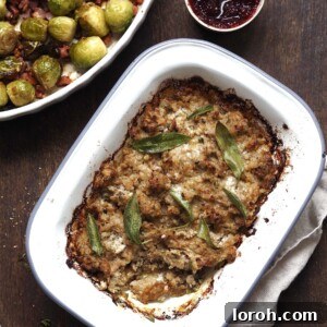 A beautifully presented baking dish of Sausage, Onion, and Sage Stuffing, golden brown and crispy on top, perfect for a holiday meal.