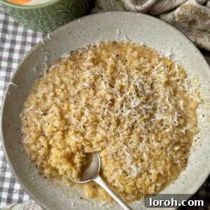 A bowl of creamy pastina with a spoon in the bowl.