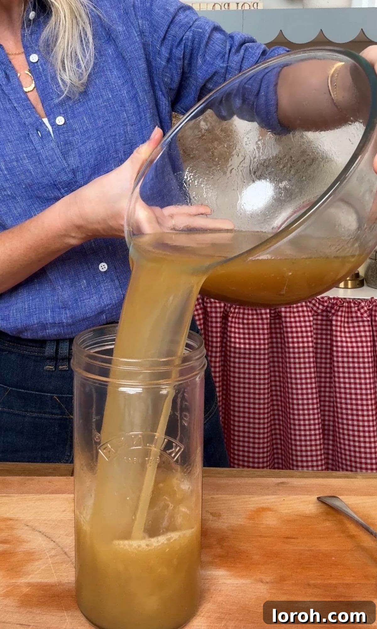 Cooling and transferring strained chicken stock into glass jars.