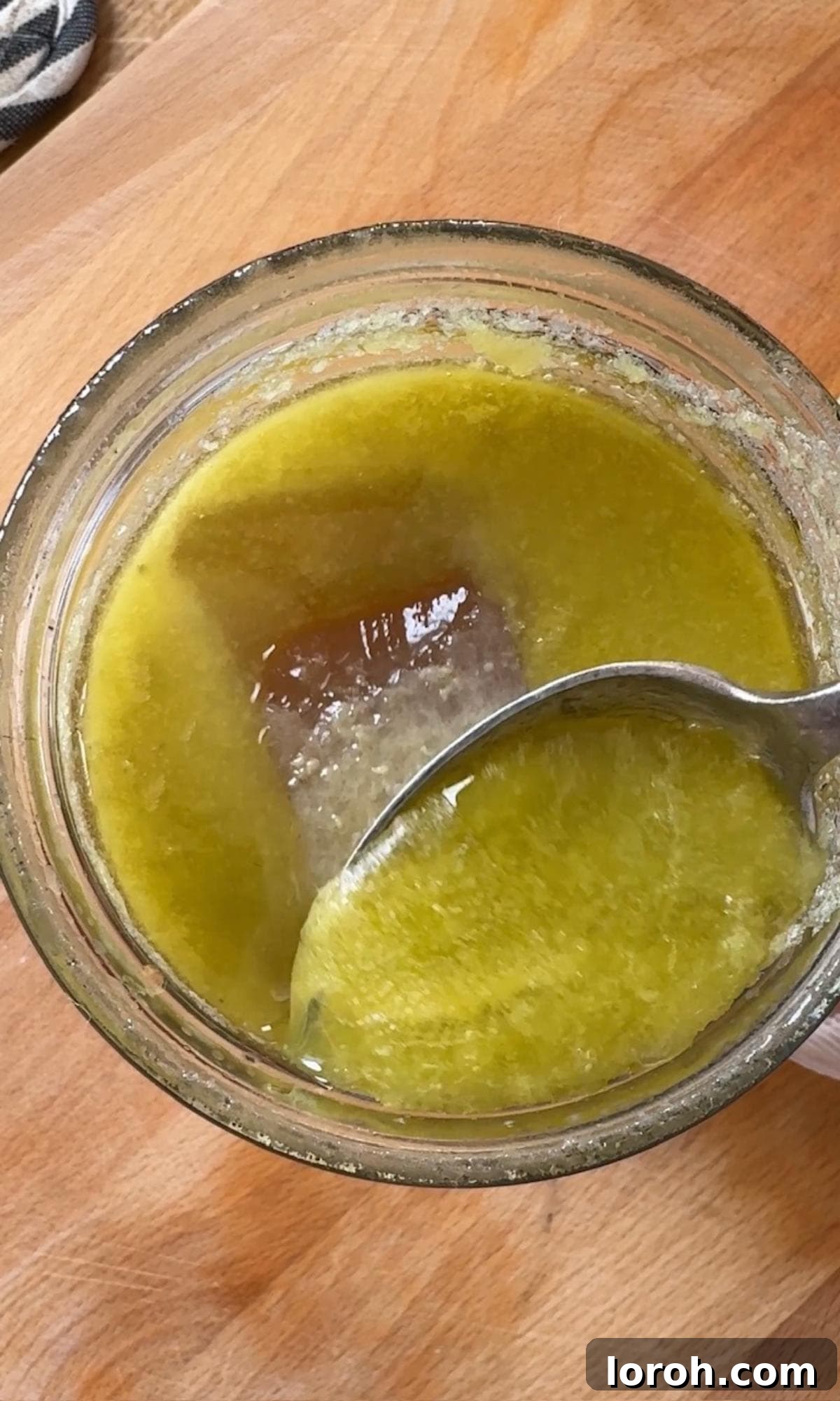Scraping solidified fat off the chilled chicken stock surface.