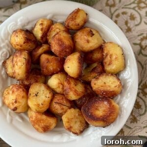 roasted white potatoes with rosemary in a white bowl.