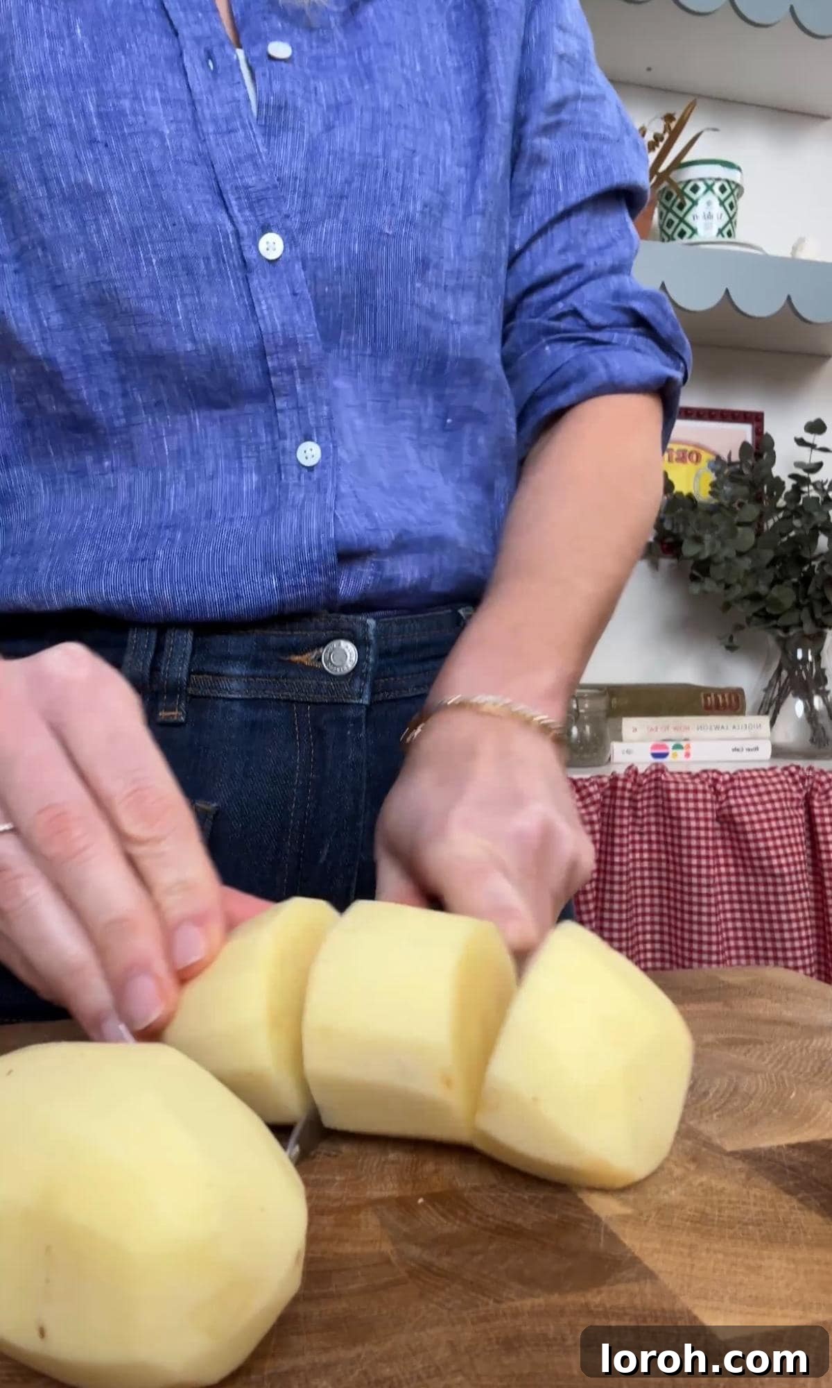 slicing white potatoes into even chunks for roasting.