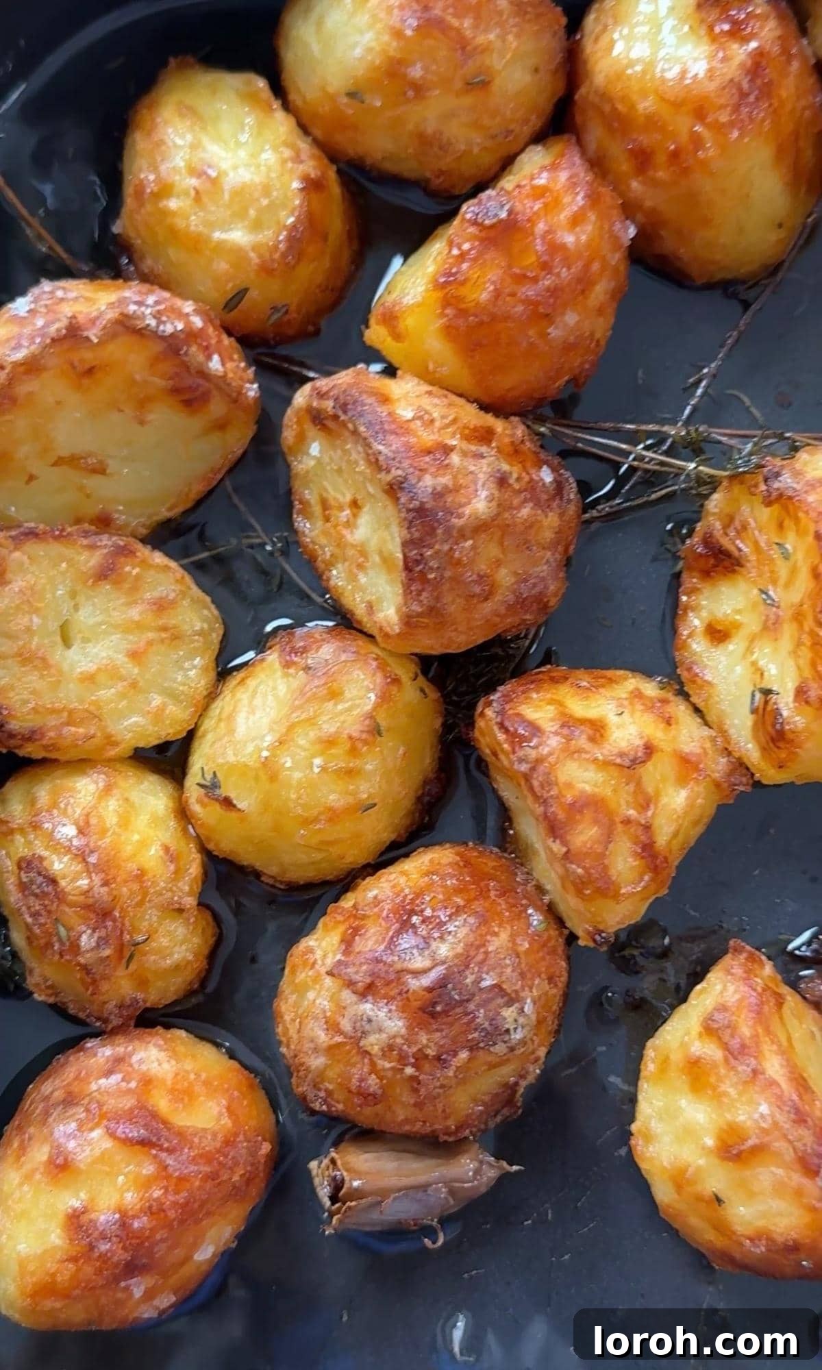 roasted white potatoes with rosemary on a baking tray, golden brown and crispy.