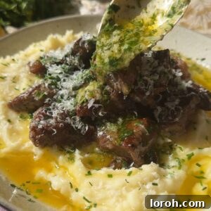 pouring garlic butter over garlic steak bites.