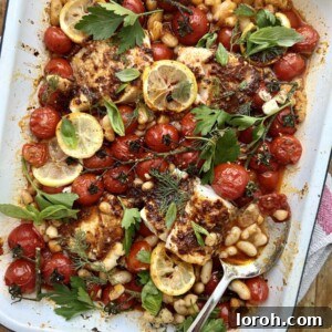 White tray of roasted tomatoes, beans and harissa cod.