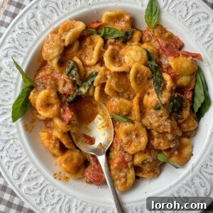 pasta con nduja in white bowl with spoon